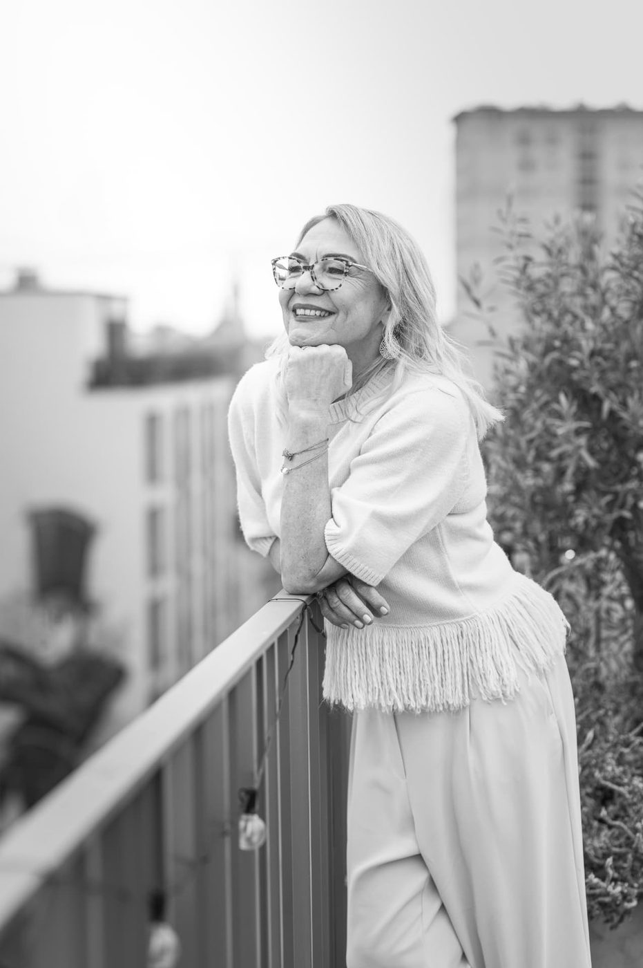 Martina Kohrgruber lächelnd auf einer Terrasse in Graz, Schwarzweiß-Portrait